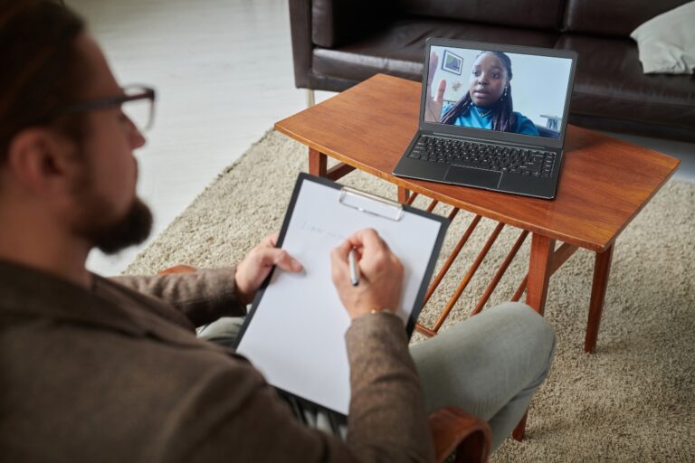 Man speaking with his psychiatrist in a consultation via his computer