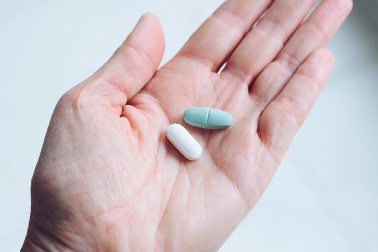 Woman holding two pills: one is Zoloft and the other is Prozac