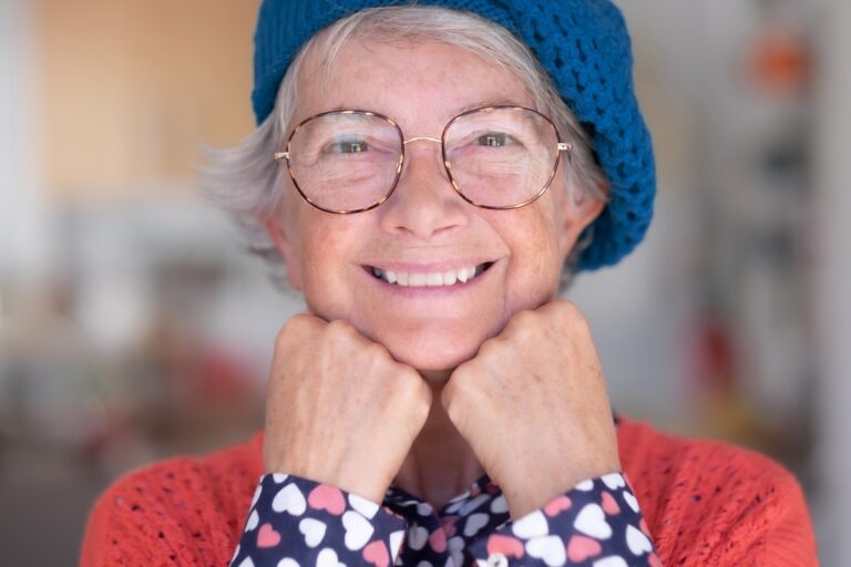 Elderly woman smiling because she takes care of her mental health while living in a retirement community in Florida.